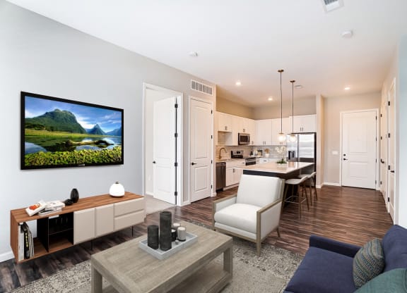 a living room with a couch and a table in front of a kitchen at Essex, Columbus