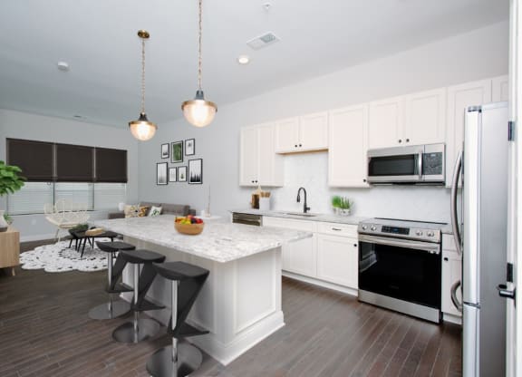 a kitchen with white cabinets and a white island with three stools at Fairfax, Grandview, OH, 43212