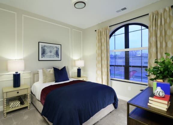 a bedroom with a large window and a bed with a blue comforter  Fairfax, Grandview