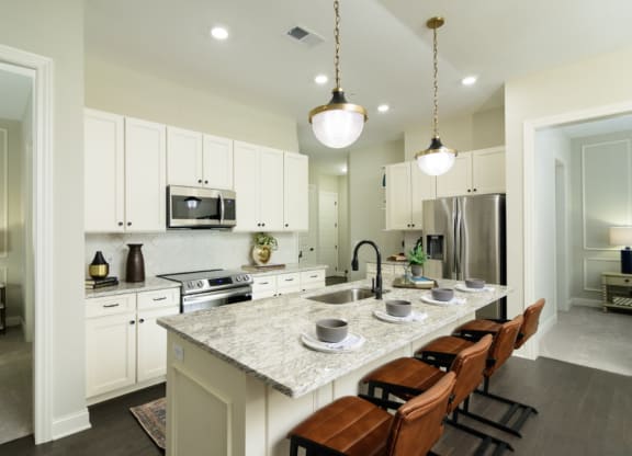 a kitchen with white cabinets and a large island with a marble countertop at Fairfax, Grandview, OH