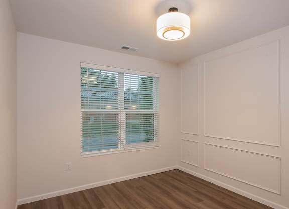 A room with a window and wooden floors.