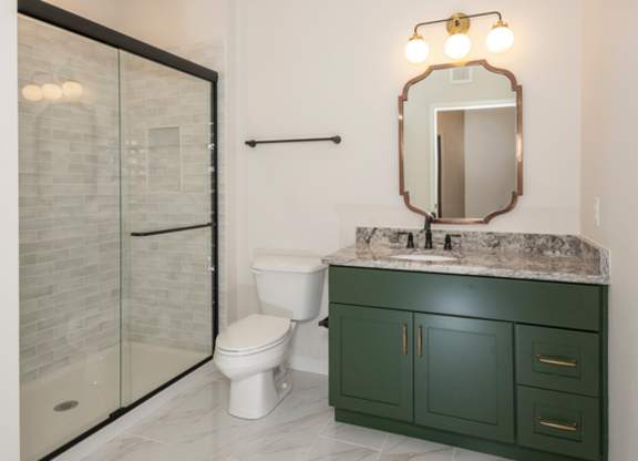 A bathroom with a green cabinet and a marble countertop.
