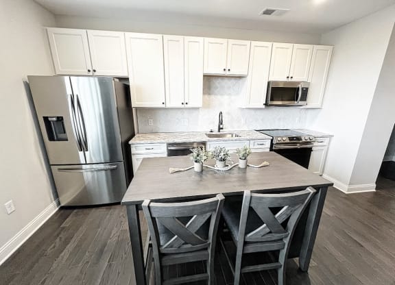 a kitchen with white cabinets and stainless steel appliances at Fairfax, Grandview, OH, 43212