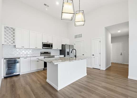 A modern kitchen with white cabinets and a central island.