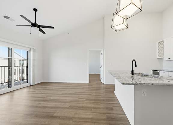A kitchen with a marble countertop and a ceiling fan.