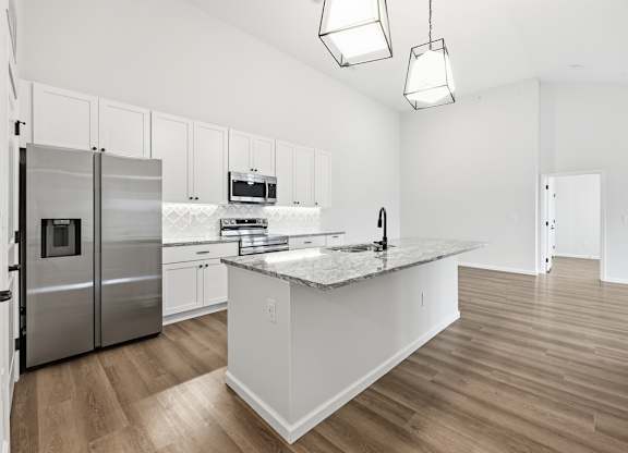 A kitchen with a stainless steel refrigerator, microwave, and oven.