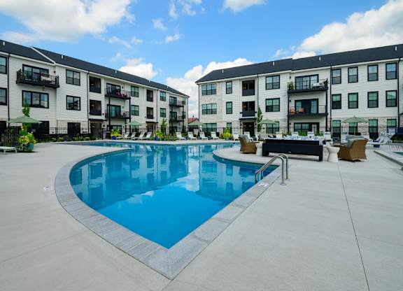 A swimming pool in front of apartment buildings.