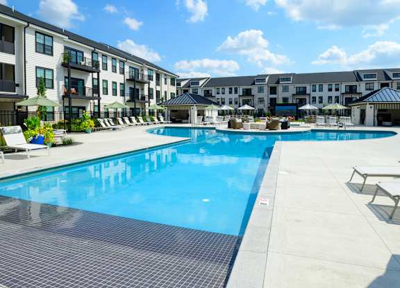 A large swimming pool surrounded by apartment buildings.