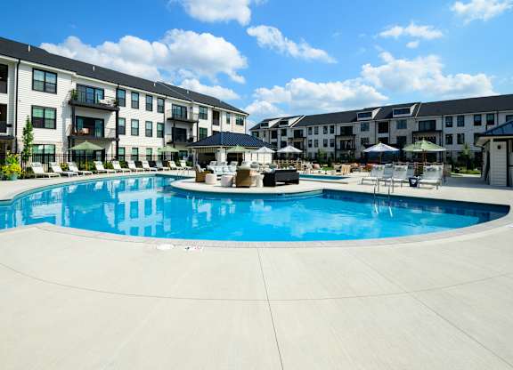 A large swimming pool in front of apartment buildings.