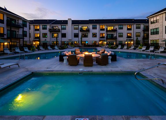 A swimming pool surrounded by lounge chairs and umbrellas at a resort.