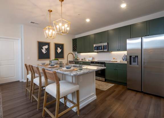 A kitchen with a table and chairs.