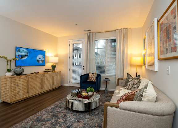 A living room with a sofa, a coffee table, and a painting on the wall.