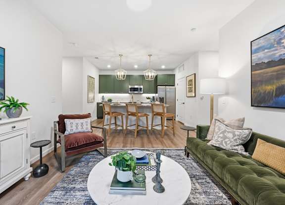 A living room with a green couch and a dining table.