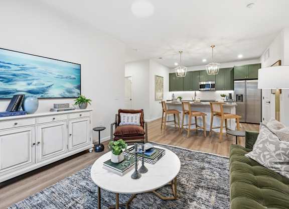 A living room with a white coffee table and a painting on the wall.