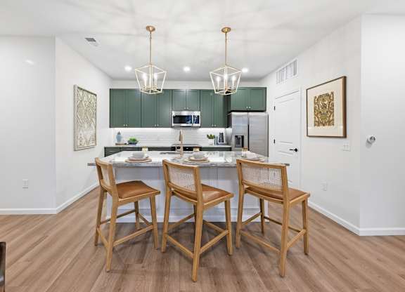 A kitchen with a table and chairs in the middle.