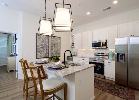 A kitchen with a table and chairs and a refrigerator.