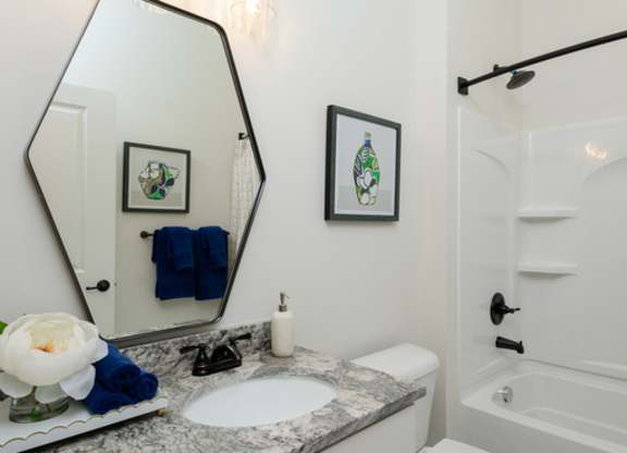 A bathroom with a white toilet and a marble counter top.