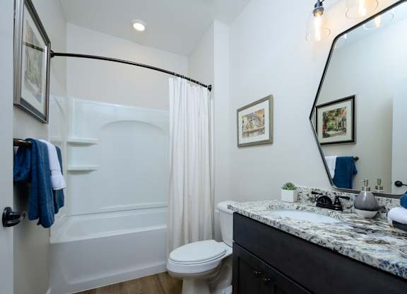 A bathroom with a white tub, toilet, and sink. at Fairmont Apartments, Westerville
