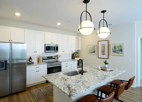 A kitchen with a granite countertop and stainless steel appliances. at Fairmont Apartments, Westerville