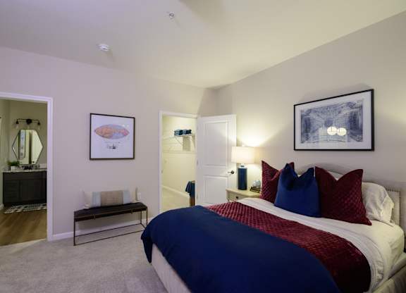 A bedroom with a bed, nightstands, and a painting on the wall. at Fairmont Apartments, Ohio