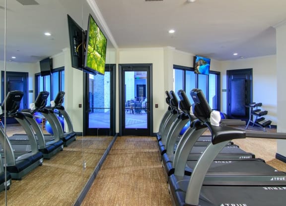 a room filled with cardio equipment and flat screen televisions  at Essex, Columbus, Ohio