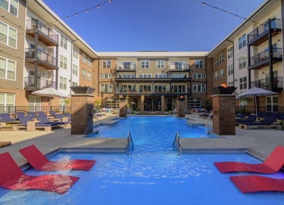 a large swimming pool with red chairs in front of an apartment buildingat Taylor House Apartments, Columbus, Ohio