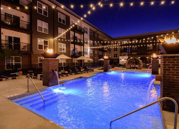 A lit up pool area at night.