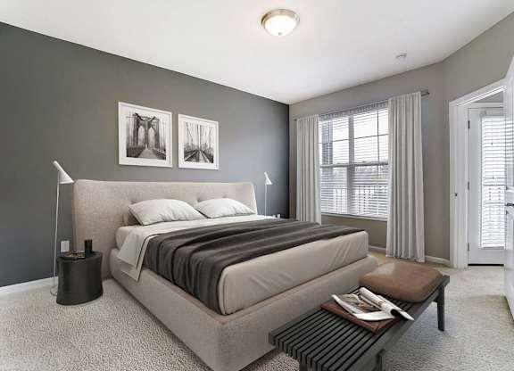 A bedroom with a large bed and a nightstand with a lamp.