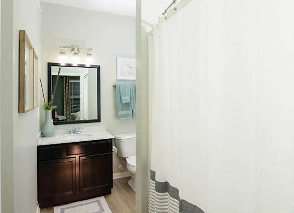 A bathroom with a white toilet and a white shower curtain.