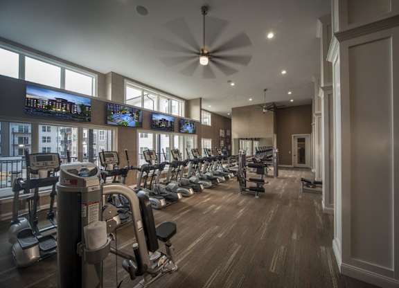 A gym with a variety of equipment including treadmills, stationary bikes, and weight machines.