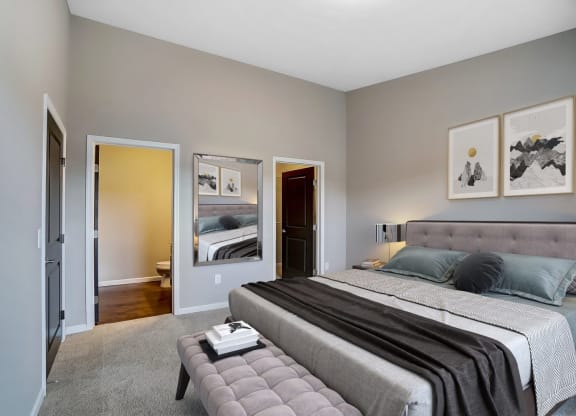 a bedroom with a large bed and a mirrorat Taylor House Apartments, Columbus, Ohio