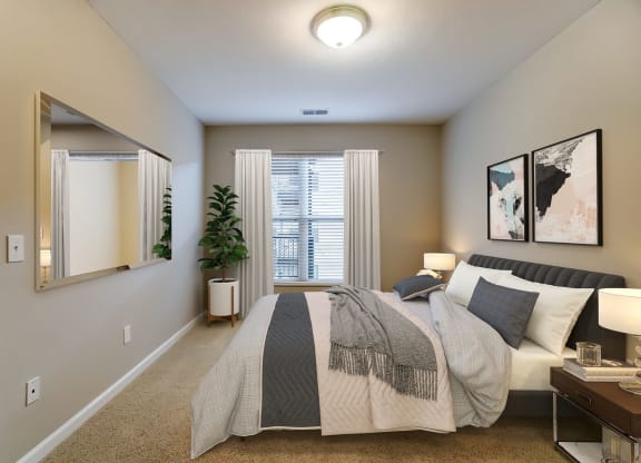 a bedroom with a bed and a mirrorat Taylor House Apartments, Columbus, OH, 43214
