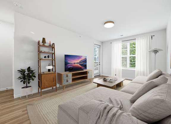 A living room with a grey couch and a wooden cabinet.