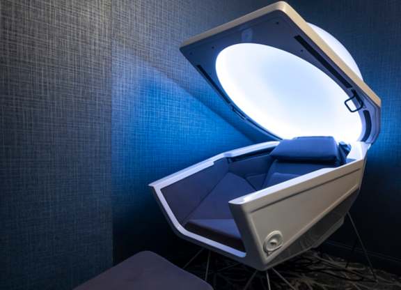 A modern chair with a unique design is illuminated by a light from the side.