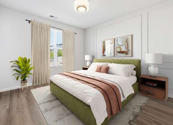 A bedroom with a large bed and a potted plant.