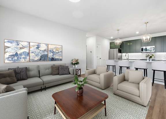 A living room with a large painting on the wall and a kitchen in the background.