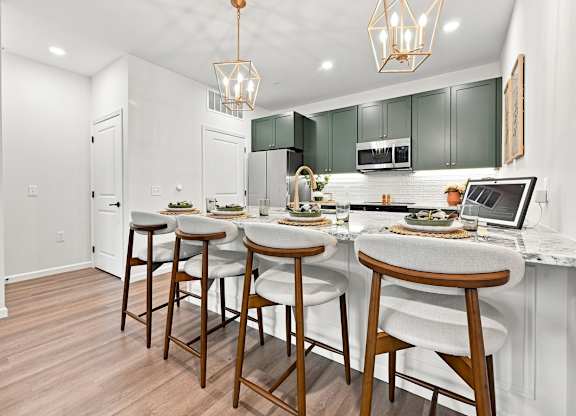 A kitchen with white walls and a wooden floor.