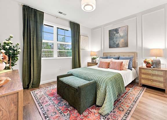 A bedroom with a bed, nightstand, and a rug.