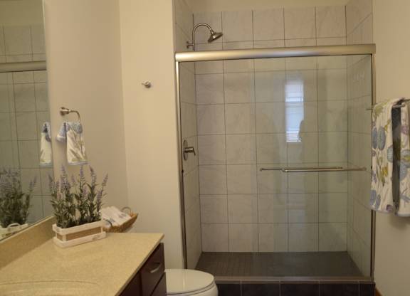 A bathroom with a toilet, sink, and shower at Cornerstone & Ravenna* Apartments, Shorewood, Wisconsin