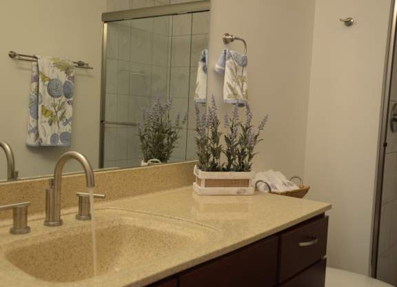 A bathroom with a sink and a mirror at Cornerstone & Ravenna* Apartments, Shorewood 53211