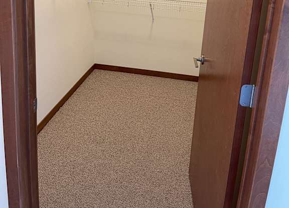 A walk-in closet with shelves and a carpeted floor at Cornerstone & Ravenna* Apartments, Shorewood, WI