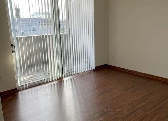 A room with a sliding door and wooden flooring at Cornerstone & Ravenna* Apartments, Shorewood, WI