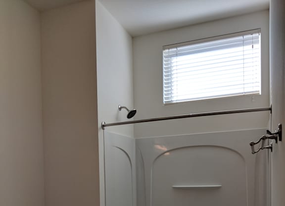A white toilet sits next to a white bathtub in a bathroom at Cornerstone & Ravenna* Apartments, Shorewood, WI, 53211