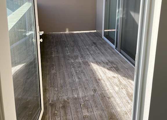 A room with a wooden floor and a glass door at Cornerstone & Ravenna* Apartments, Shorewood