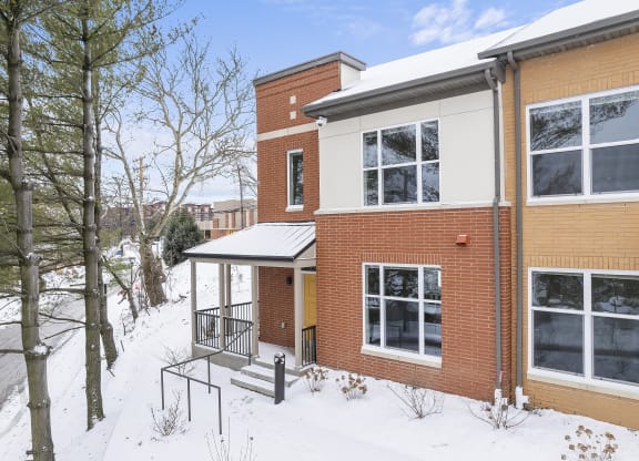 the front of a brick house in the snow