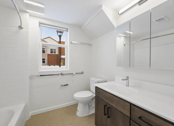 a bathroom with a toilet sink and shower and a window