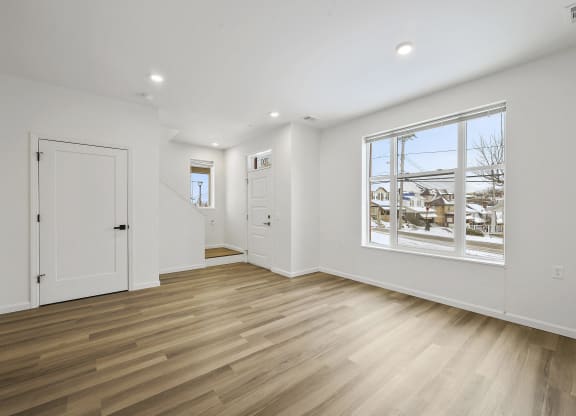 a living room with a large window and white walls