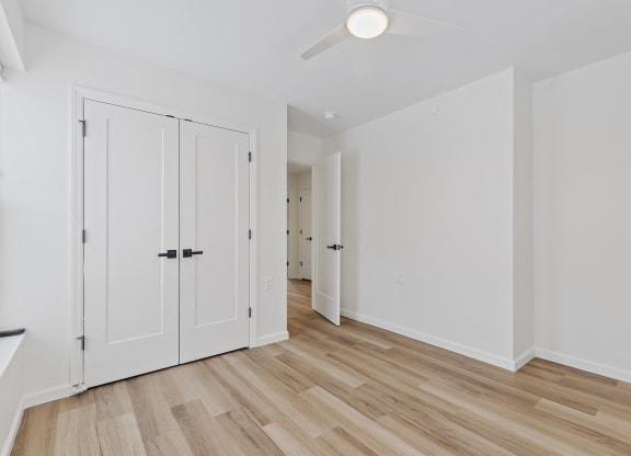 a living room with white doors and a hard wood floor