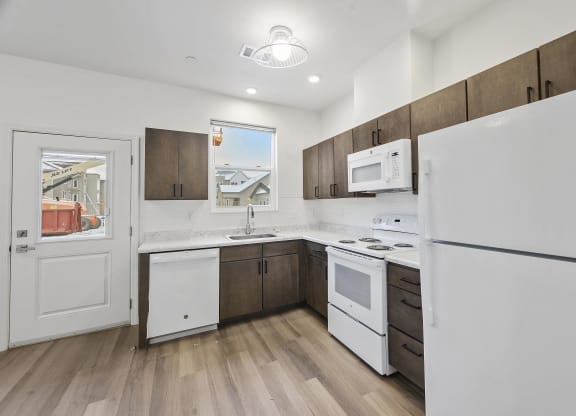 a kitchen with white appliances and wooden cabinets and a white refrigerator