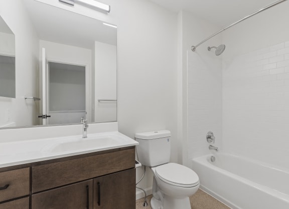 a bathroom with a toilet sink and tub and a mirror